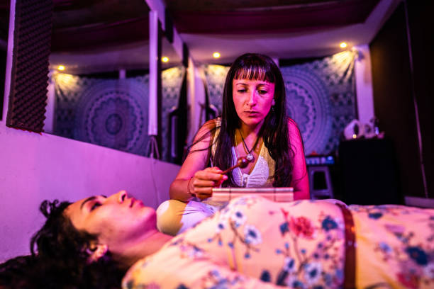 Therapist taking care of her patient during holistic therapy session at spa HYPNOSE RÉGRESSIVE À SANS SOUCI-DAUPHINÉ