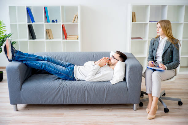 Young man on reception at psychologist lying on couch HYPNOSE RÉGRESSIVE À SANS SOUCI-DAUPHINÉ